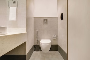 Un baño moderno con inodoro, ducha y lavamanos.