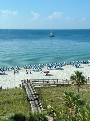 A beach with a wooden boardwalk, beach umbrellas, and lounge chairs. - Indigo East 601 4 Bedroom Corner Unit w/ Large Balcony, Updated & Owner Managed (Pensacola)