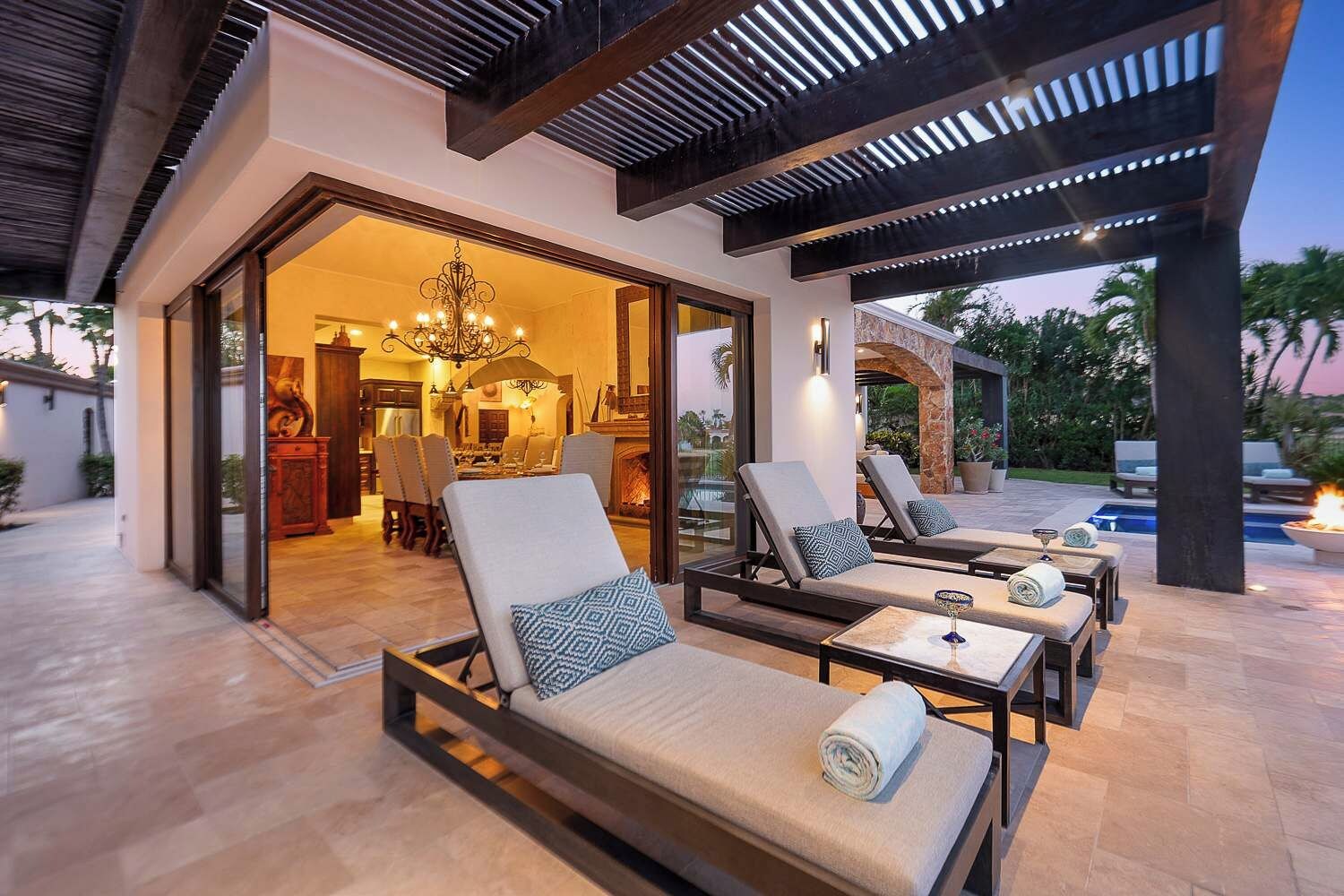 An outdoor lounge area with sun loungers and a pool.