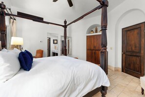 A four-poster bed with white bedding, a wooden wardrobe, and a door in a hotel room. - Luxury Palmilla Golf 4BR Villa w/ Pool & Jacuzzi (San José del Cabo)