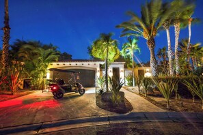 A residential property with a garage, palm trees, and a vehicle parked in front. - Luxury Palmilla Golf 4BR Villa w/ Pool & Jacuzzi (San José del Cabo)
