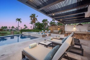 A poolside area with lounge chairs, a barbecue, and a stone wall. - Luxury Palmilla Golf 4BR Villa w/ Pool & Jacuzzi (San José del Cabo)