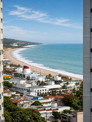 A coastal cityscape with a beach, buildings, and a clear sky. - CJC Short Stay Paradise (Natal)