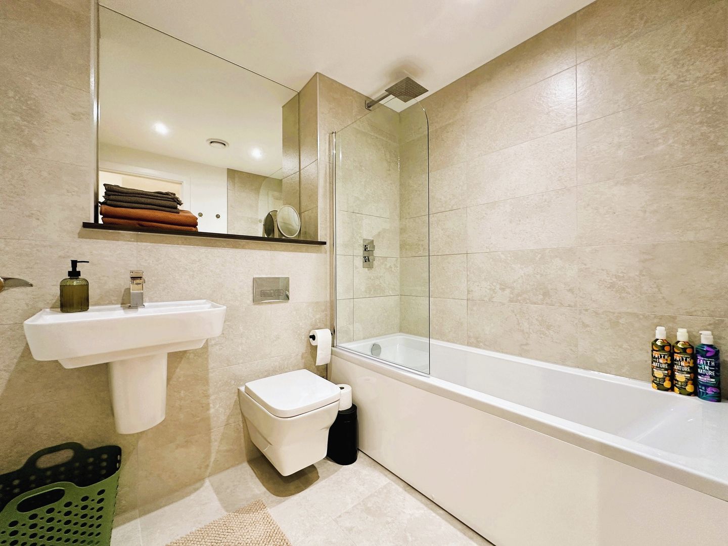 A modern bathroom with a glass-enclosed shower, a white sink, and a toilet.