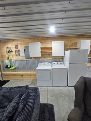 A laundry room with a washing machine, dryer, and stacked cabinets.