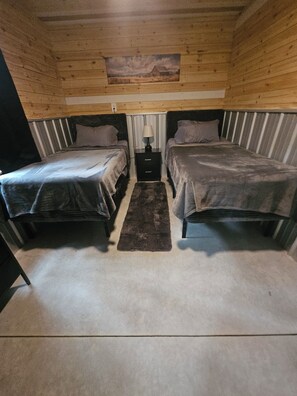 A cabin interior with two beds, a nightstand, a lamp, and a painting on the ceiling. - The bunkhouse at Wilco Farms (Millen)