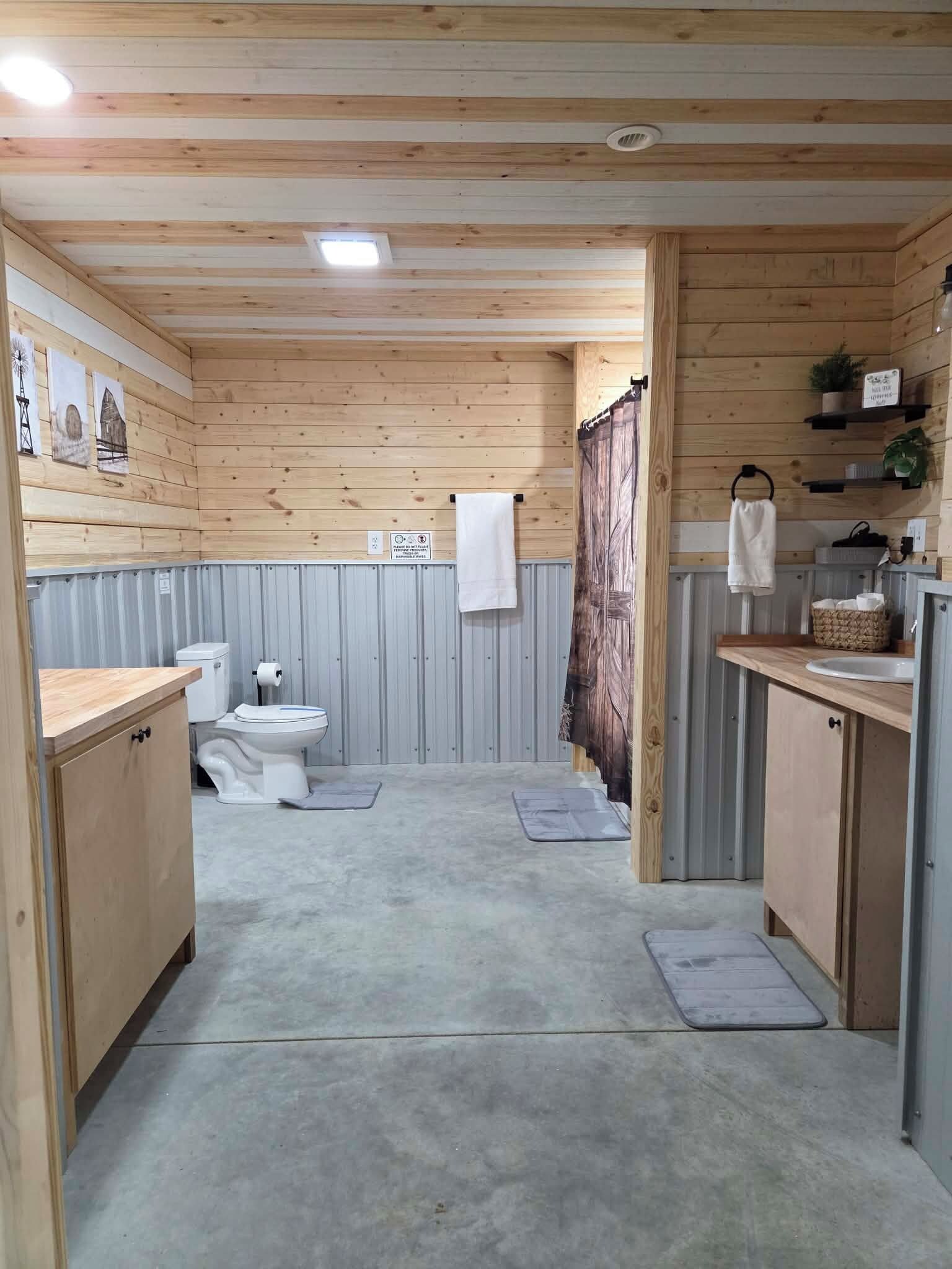 Casa de banho compacta em madeira com sanita, lavatório e zona de duche.