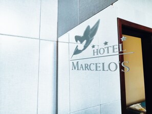 A hotel sign with a bird logo and the name 'Hotel Marcelo's' on a tiled wall. - Hotel Marcelo's (Loreto)