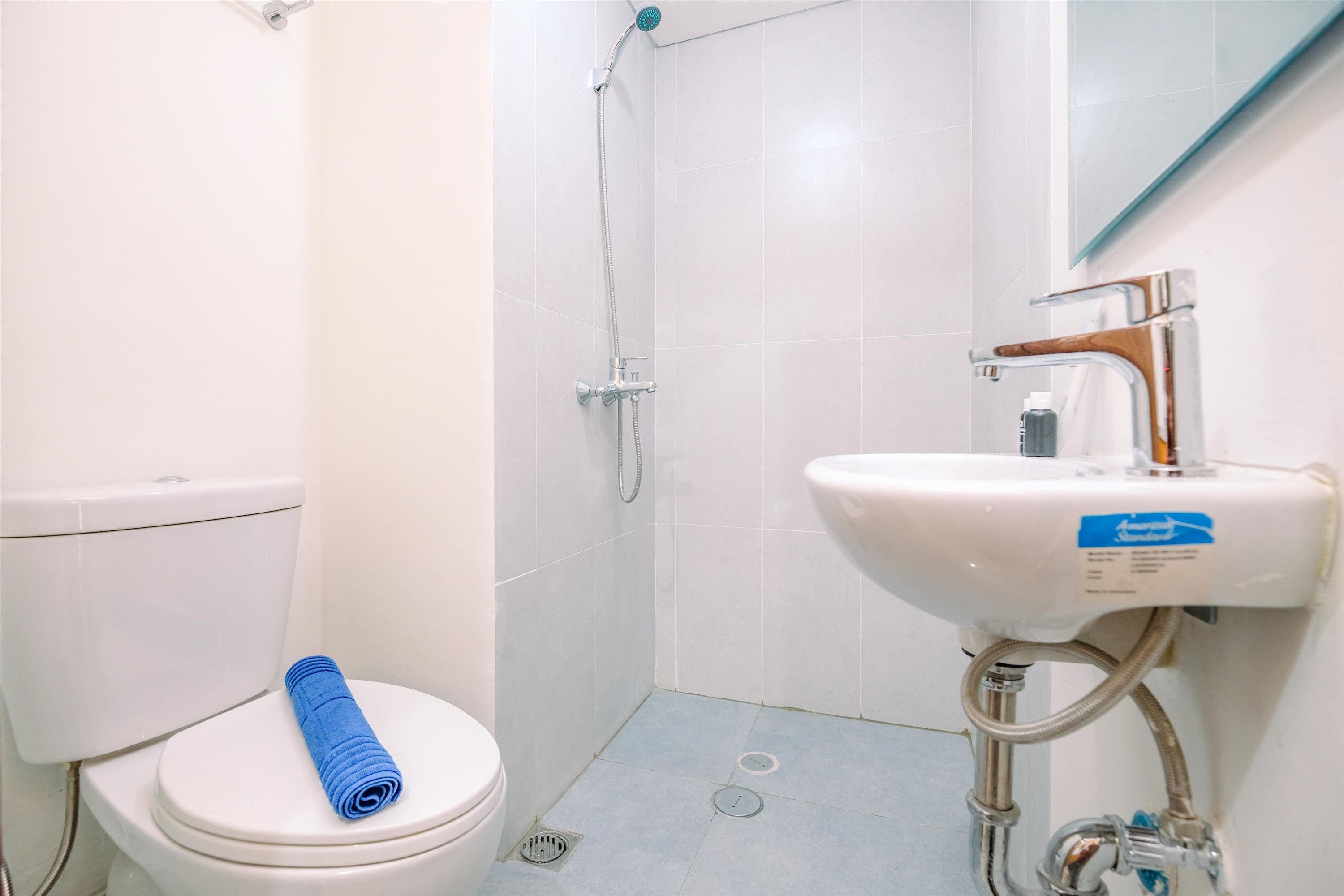 A bathroom with a toilet, a shower, and a sink.