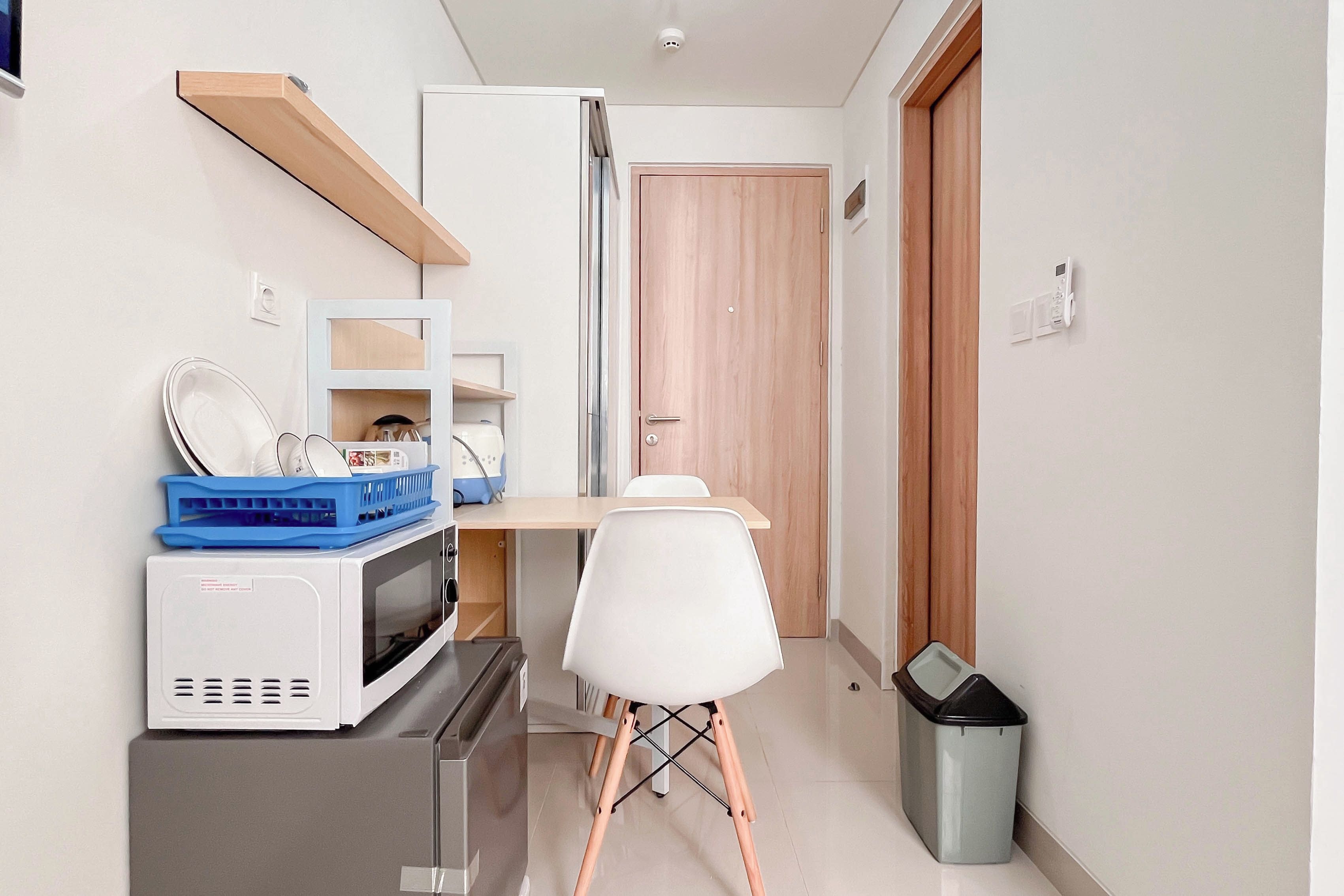 A compact kitchenette with a microwave, stove, and small fridge.