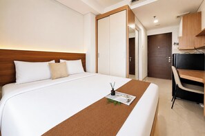 A hotel room with a bed, a desk, and a wardrobe. - Smart Living Studio At Apartment Springwood Residence Tangerang (Tangerang)