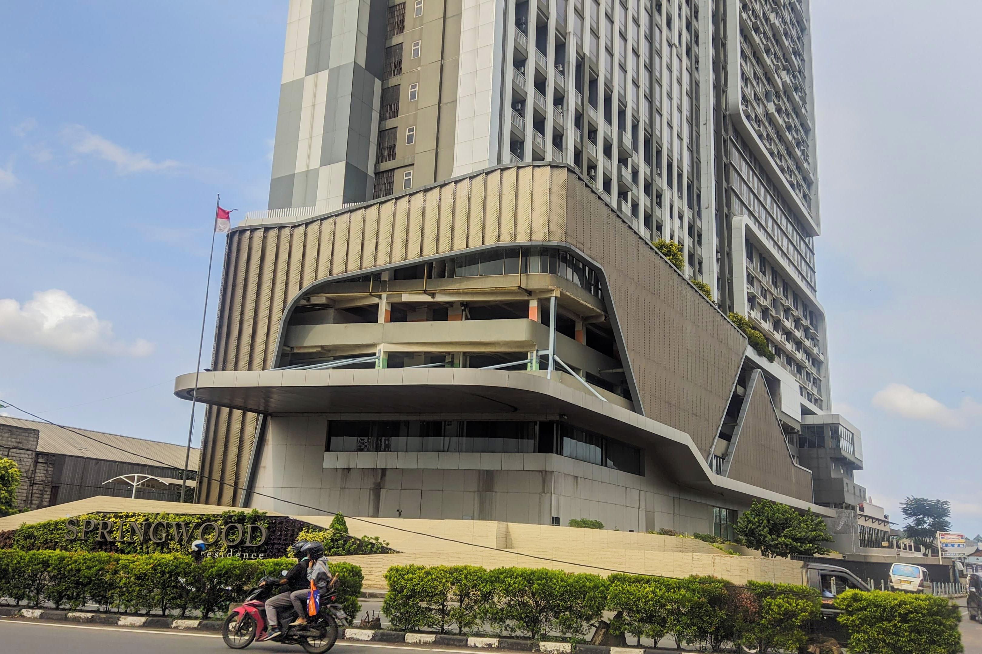 Un edificio moderno de gran altura con fachada curva y varios balcones.
