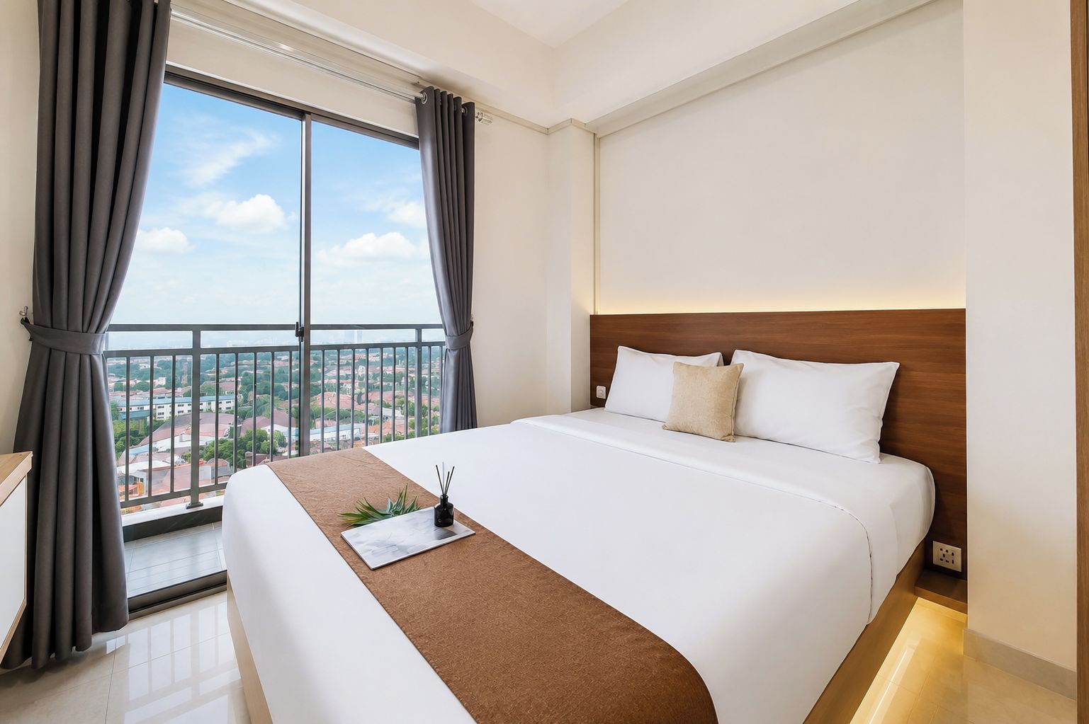 Habitación de hotel con una cama grande, vistas a la ciudad y un balcón.
