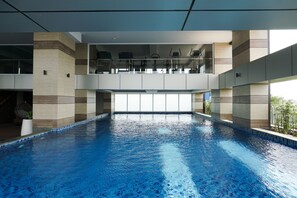 A large indoor swimming pool with a clear view of the sky through the ceiling. - Elegant 2Br Loft Apartment Maqna Residence (Jakarta)