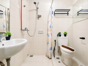 A bathroom with a sink, toilet, shower, and a towel rack. - Strategic And Cozy 1Br At Apartment Thamrin Residence (Jakarta)