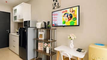 A compact kitchenette with a refrigerator, microwave, and coffee maker.