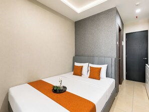 Ein modernes Hotelzimmer mit Bett, Nachttisch und Tür.
