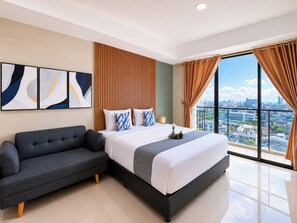 A modern hotel room with a large bed, a sofa, and a city view. - Fully Furnished Studio Apartment Nine Residence (Jakarta)