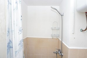 A bathroom with a shower, a towel rack, and a toilet. - Bright And Comfy 2Br Apartment Podomoro Golf View (Depok)