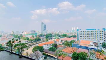 A cityscape with a prominent modern skyscraper, a mix of residential and commercial buildings, and a clear sky.