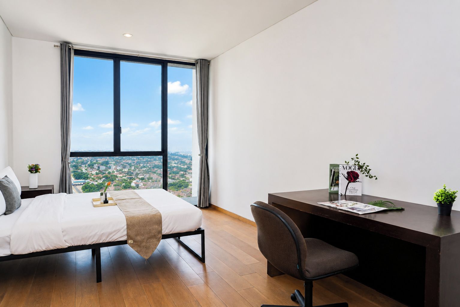 Habitación de hotel moderna con una cama grande, un escritorio y vistas a la ciudad.