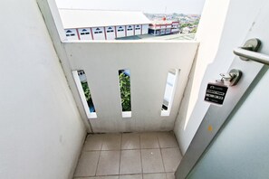 A narrow stairwell with a metal handrail and a door with a lock and a keyhole. - Nice Studio For 2 Pax At Urbantown Serpong Apartment (Tangerang)