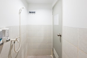 A small, enclosed shower area with a handheld showerhead, a wall-mounted faucet, and a soap dispenser. - Nice Studio For 2 Pax At Urbantown Serpong Apartment (Tangerang)