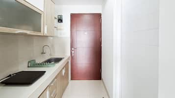 Una cocina estrecha con un lavamanos, armarios y una puerta.