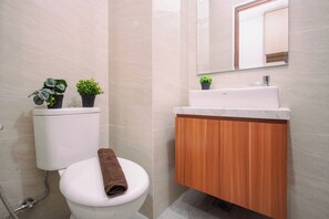 Ein Badezimmer mit Toilette, Waschbecken und Spiegel.