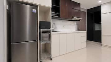 A modern kitchen with stainless steel appliances, white cabinetry, and a tiled floor.