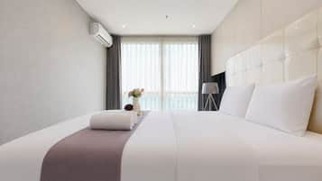 Ett hotellrum med en stor säng, en sänglampa och utsikt över omgivningarna.