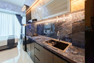 Una cocina moderna con encimera negra, pileta de acero inoxidable y cocina integrada.