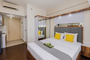 A hotel room with a bed, bedside table, and a mirror. - Modern Sleek Studio At Apartment Springlake Summarecon Bekasi (Bekasi)