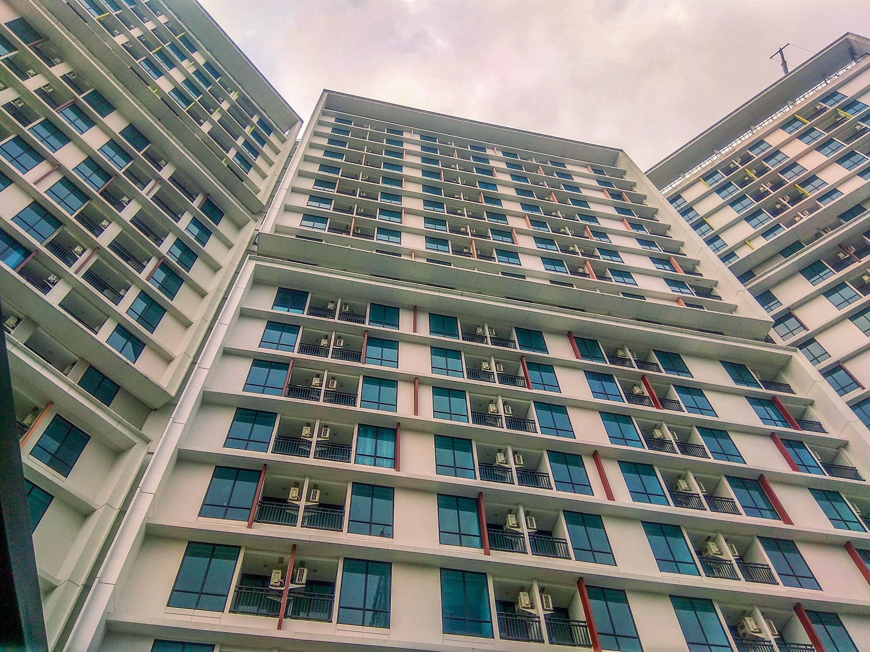 Un edificio de varios pisos con un diseño arquitectónico moderno, que cuenta con balcones en cada planta.