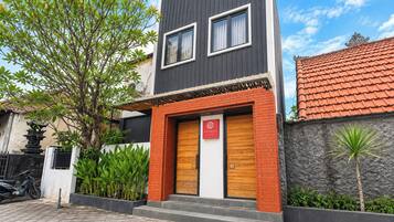 Un edificio moderno de dos pisos con una puerta de madera y un cartel que indica 'Villa Mekar'.
