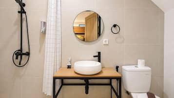Ein Badezimmer mit Dusche, Waschbecken, Toilette und Spiegel.