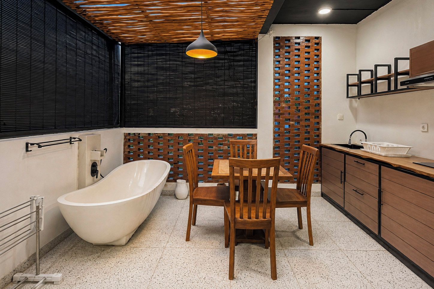 A modern bathroom with a freestanding bathtub, wooden chairs, and a dining table.