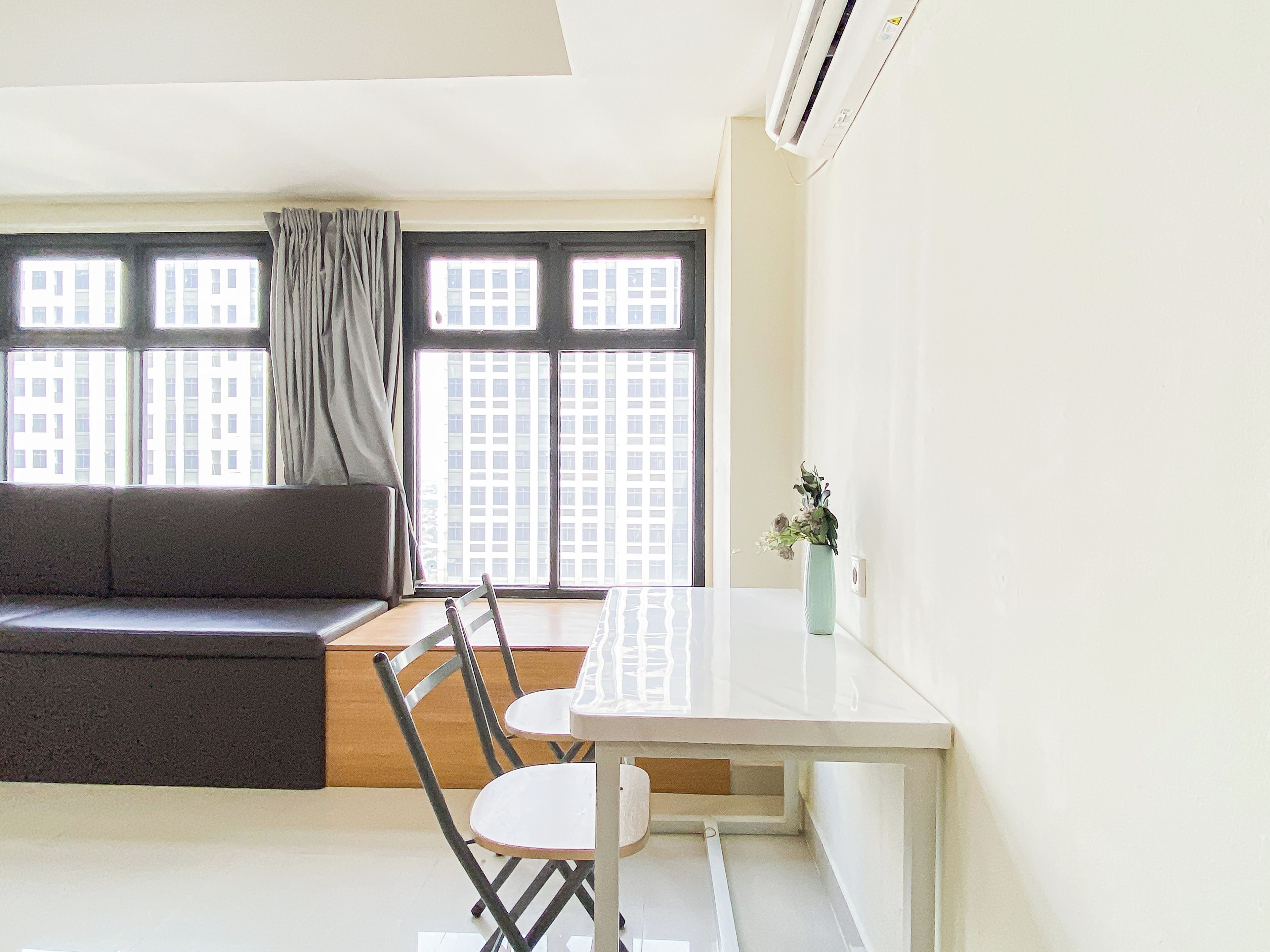 A modern living space with a sofa, a dining table, and chairs.