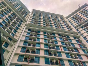 A multi-story building with a modern architectural design, featuring balconies on each floor. - Bright And Relaxing 1Br At Apartment Lrt City Bekasi (Bekasi)