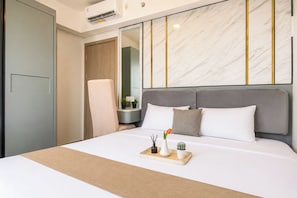 Ein Hotelzimmer mit Bett, Nachttisch, Sessel und Kleiderschrank.