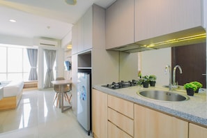 Una cocina moderna con un lavamanos de acero inoxidable, una estufa integrada y armarios de madera.
