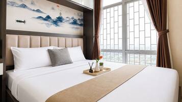 A hotel room with a large bed, a headboard with a painting, a window with curtains, and a view of the city.