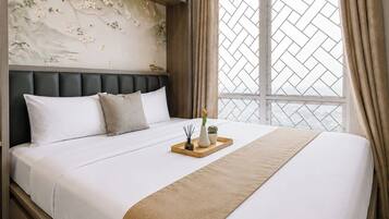 A hotel room with a bed, a headboard, a window with a view, and a decorative wall.