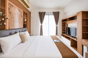 Ein Hotelzimmer mit einem großen Bett, einem Fernseher und einem hölzernen Kleiderschrank.