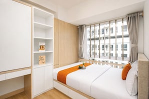Ein modernes Schlafzimmer mit Bett, Kleiderschrank und einem Fenster mit Vorhängen.