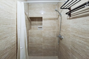 A shower with a glass door, a towel rack, and a vent on the wall. - Bright And Airy Studio At Apartment Transpark Bintaro (Tangerang)