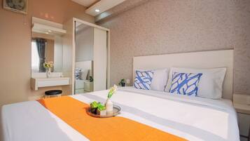A hotel room with a large bed, a bedside table, a mirror, and a window with curtains.