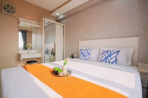 A hotel room with a large bed, a bedside table, a mirror, and a window with curtains. - Sophisticated 2Br At Apartment Podomoro Golf View (Depok)