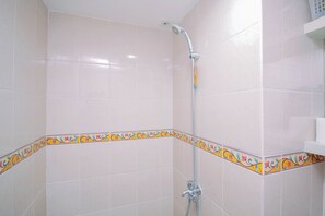 A shower area with a showerhead, a handheld shower attachment, and a wall-mounted faucet. - Sophisticated 2Br At Apartment Podomoro Golf View (Depok)