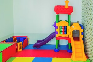 A play area with a slide, a climbing structure, and a storage box. - Affordable Neat 1Br At Apartment Brooklyn Alam Sutera (Tangerang)